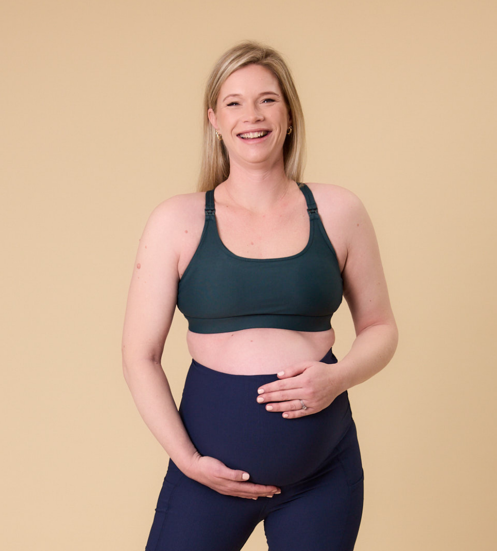 Front view of happy pregnant mother wearing maternity nursing bra in dark green