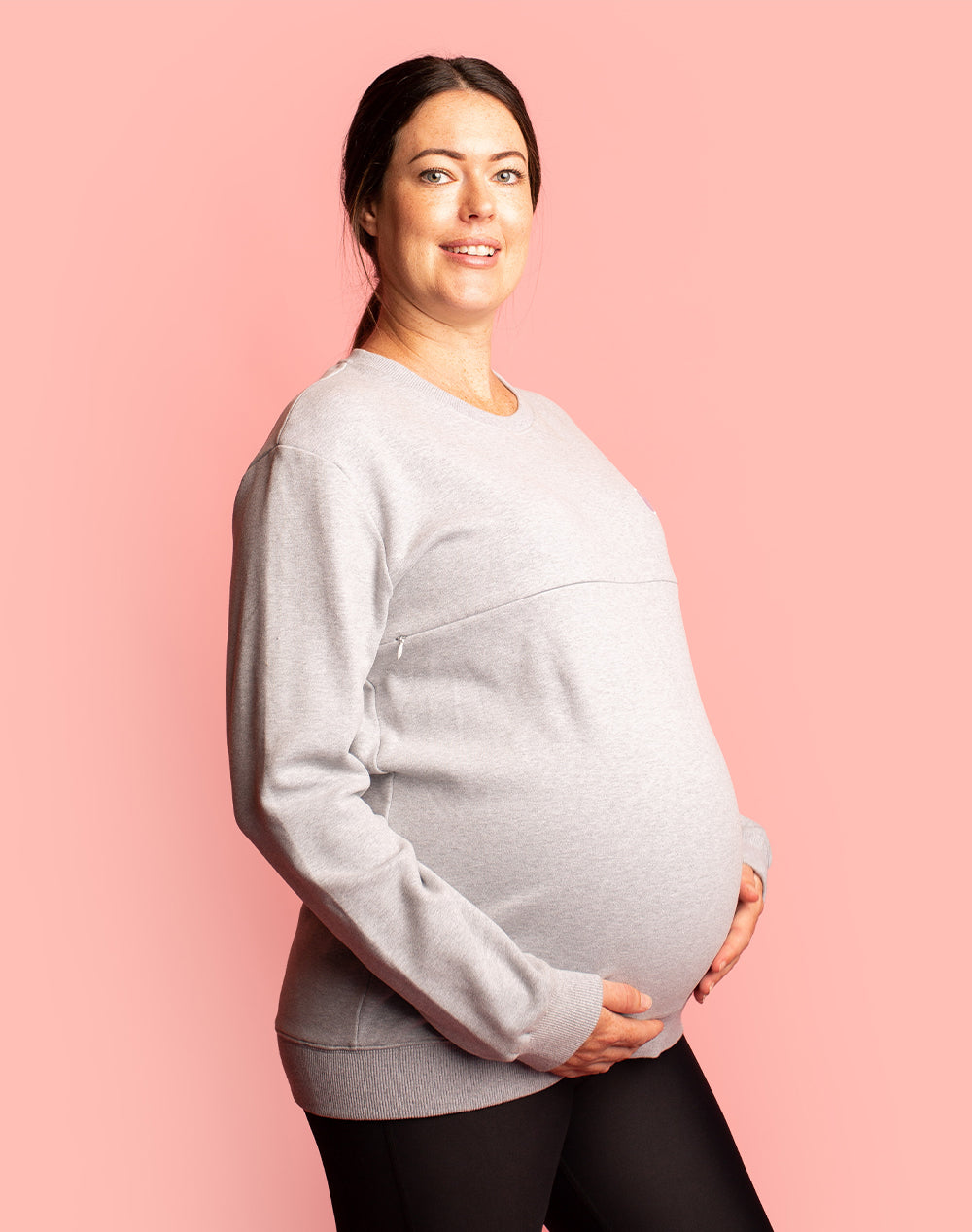 Expecting mother wearing a grey breastfeeding sweatshirt