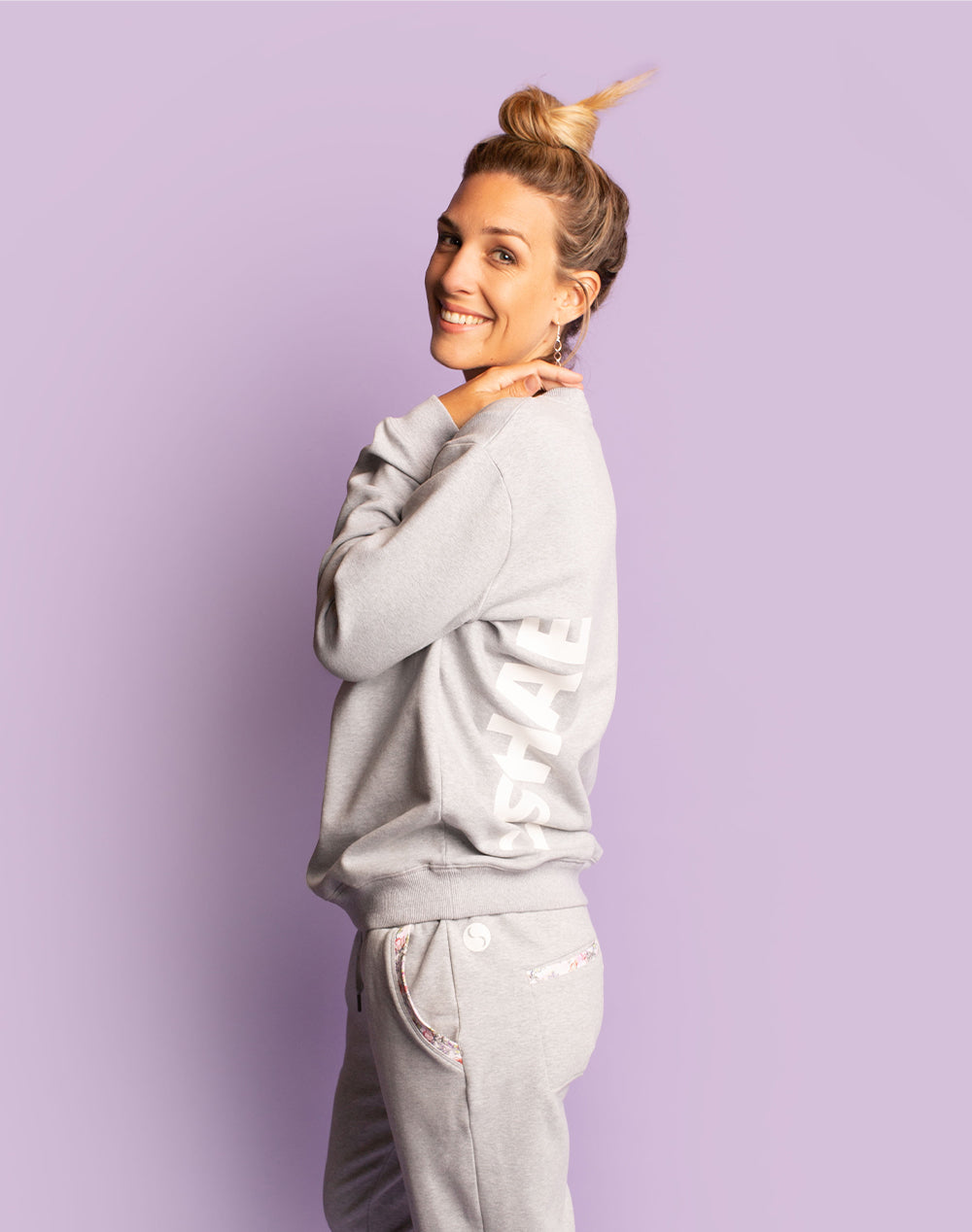 Active mother wearing matching grey women's crew sweatshirt and trackpants