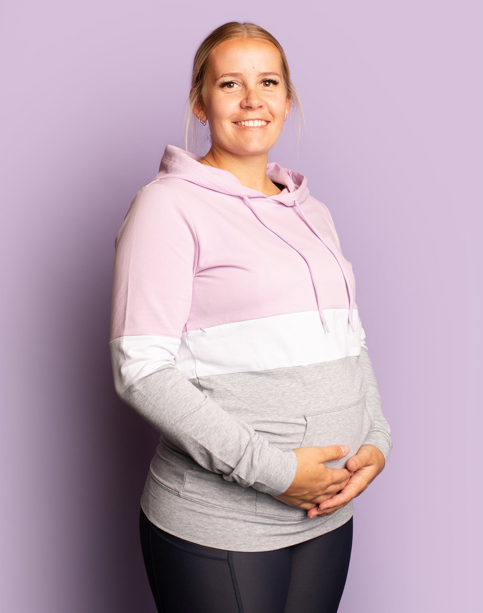 Pregnant mother holding her bump wearing maternity sweatshirt