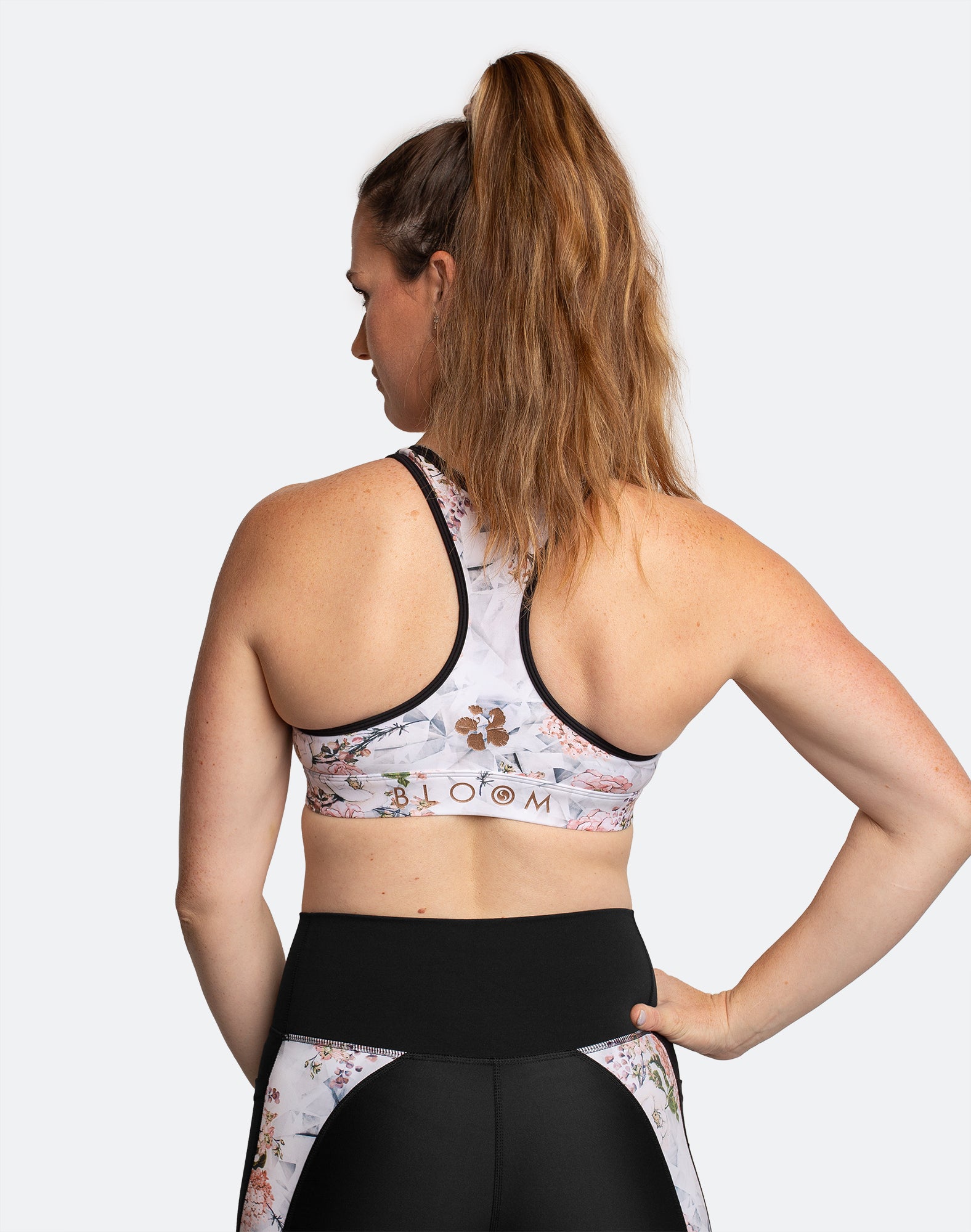 Back view of fit mum wearing white floral with black trim maternity matching co-ordinates