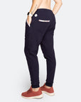 Side view of navy blue trackpants showing pocket function and white floral trim detailing