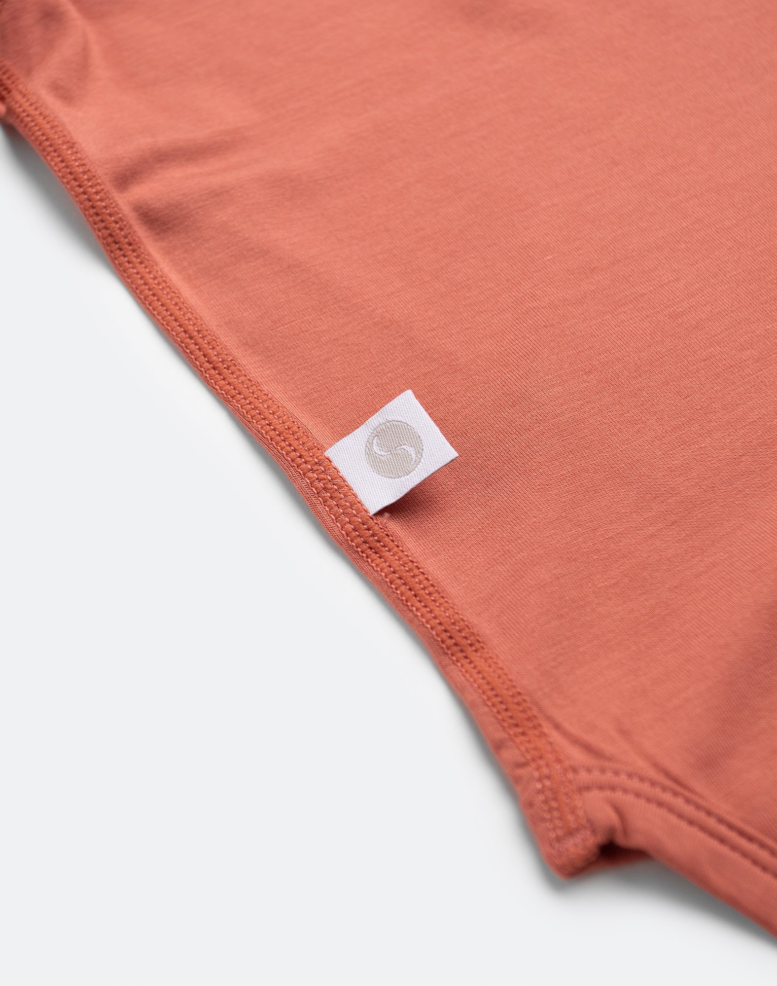 Orange baby onesie in bamboo material