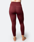 Back view of active mum wearing 7/8 high waisted leggings in bordeaux