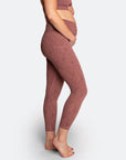 Side view of pregnant mum holding her bump wearing high waisted leggings