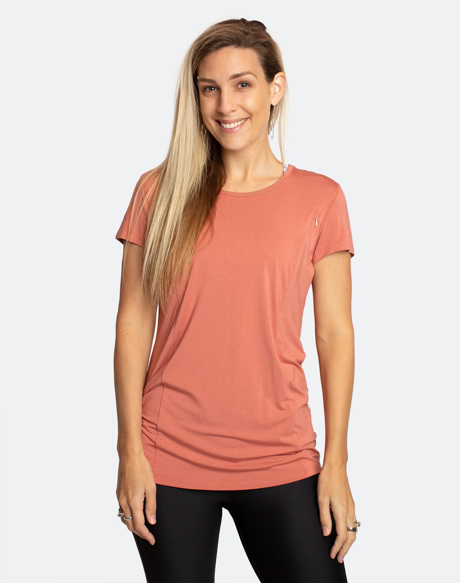 active mother wearing a light orange breastfeeding top and tights