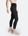 Side view of active Mum wearing black postpartum compression pants and breastfeeding sports bra