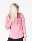 front view of a mum wearing a pink maternity top with long sleeves and invisible zips