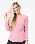 active mum wearing a pink maternity top with long sleeves and invisible zips for breastfeeding