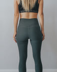 Back view of high waisted maternity tights in dark green