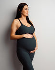 Pregnant mother holding her bump in ribbed maternity leggings