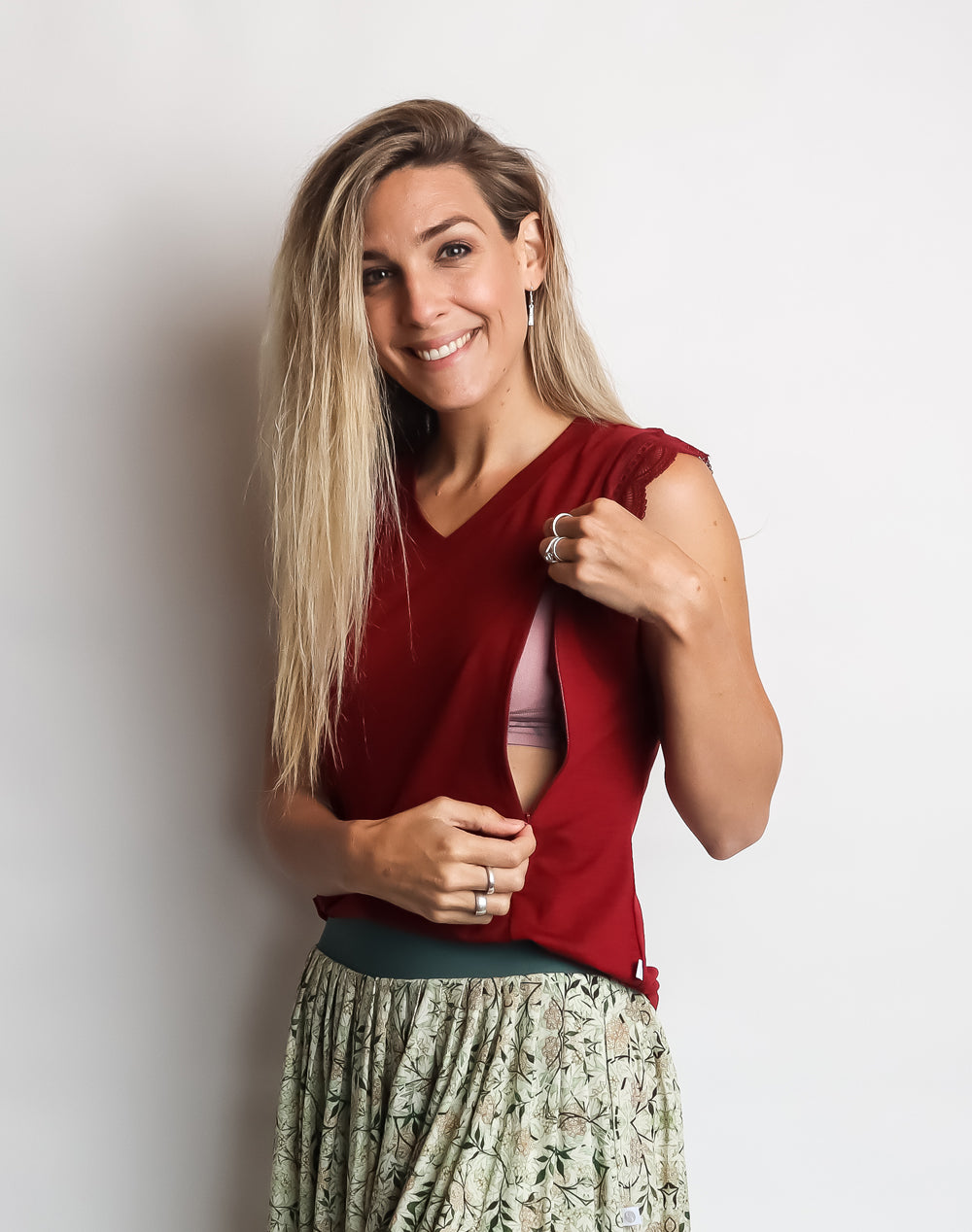 Model showing breastfeeding function on red maternity top