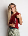 Model showing breastfeeding function on red maternity top