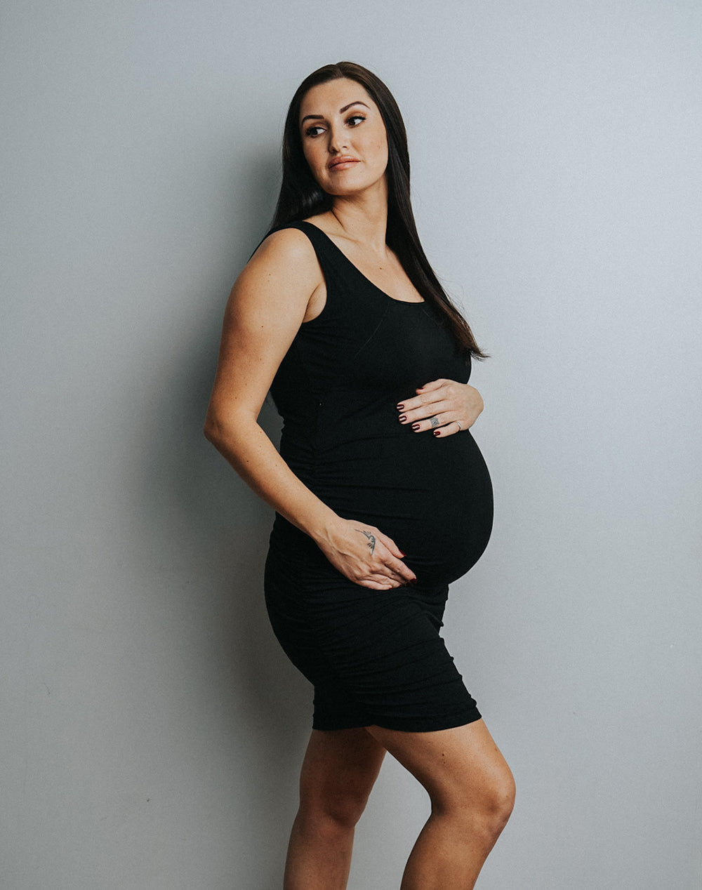 Expecting mother wearing maternity & nursing tank dress black