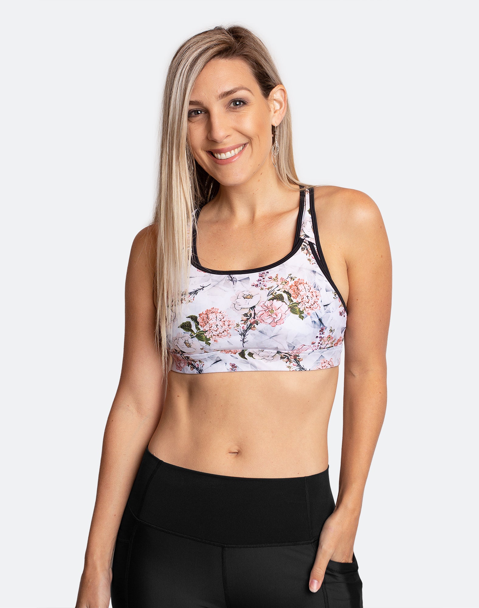 Front view of active mum wearing white floral nursing bra with black trim