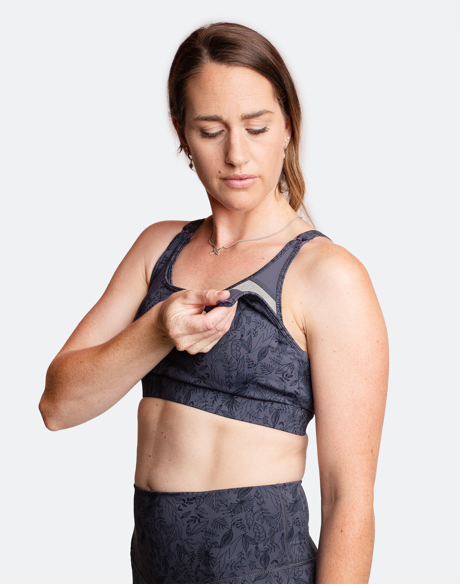 Active mum showing the breastfeeding function of a nursing sports bra