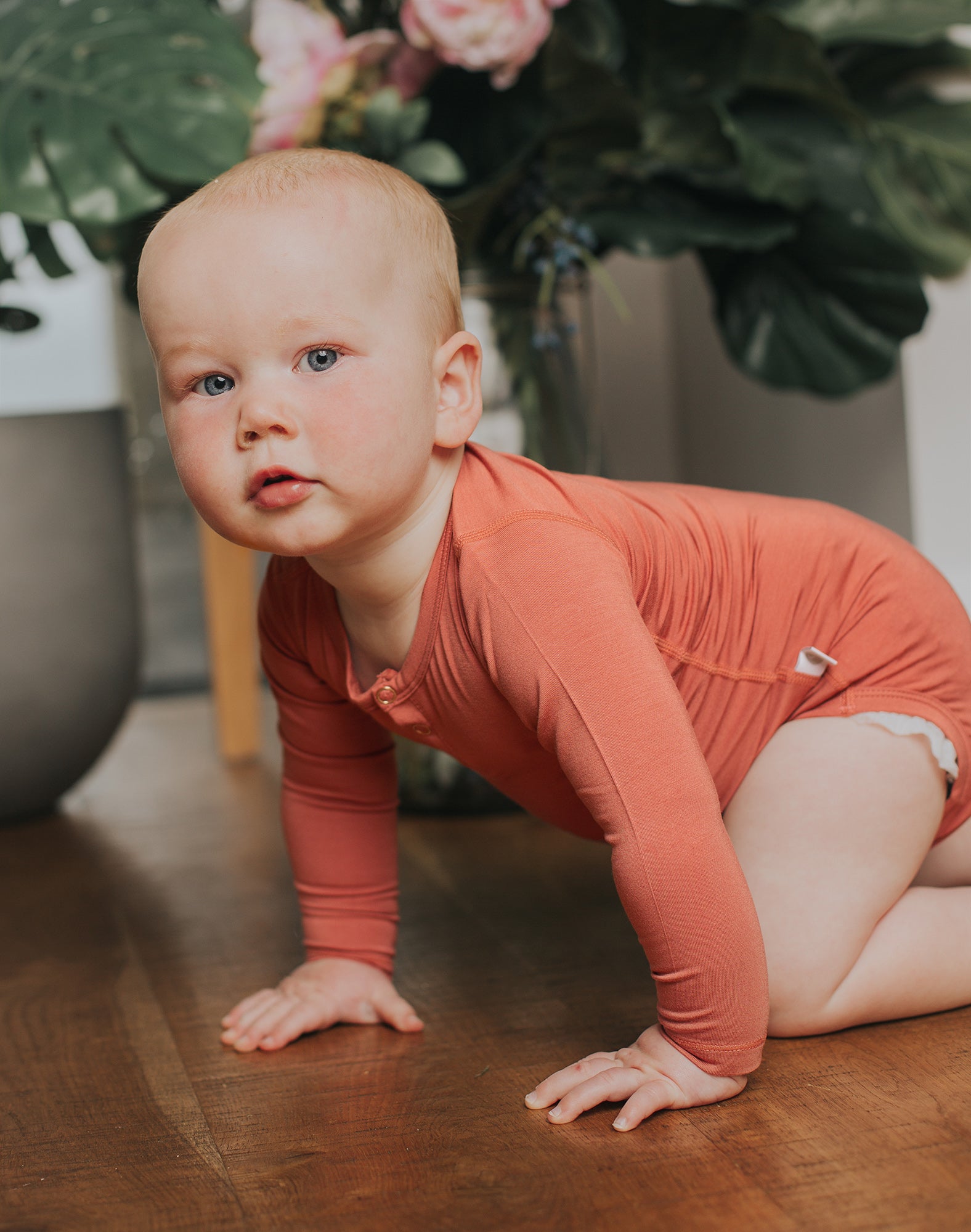 1 year old baby wearing rust orange neutral baby onesie