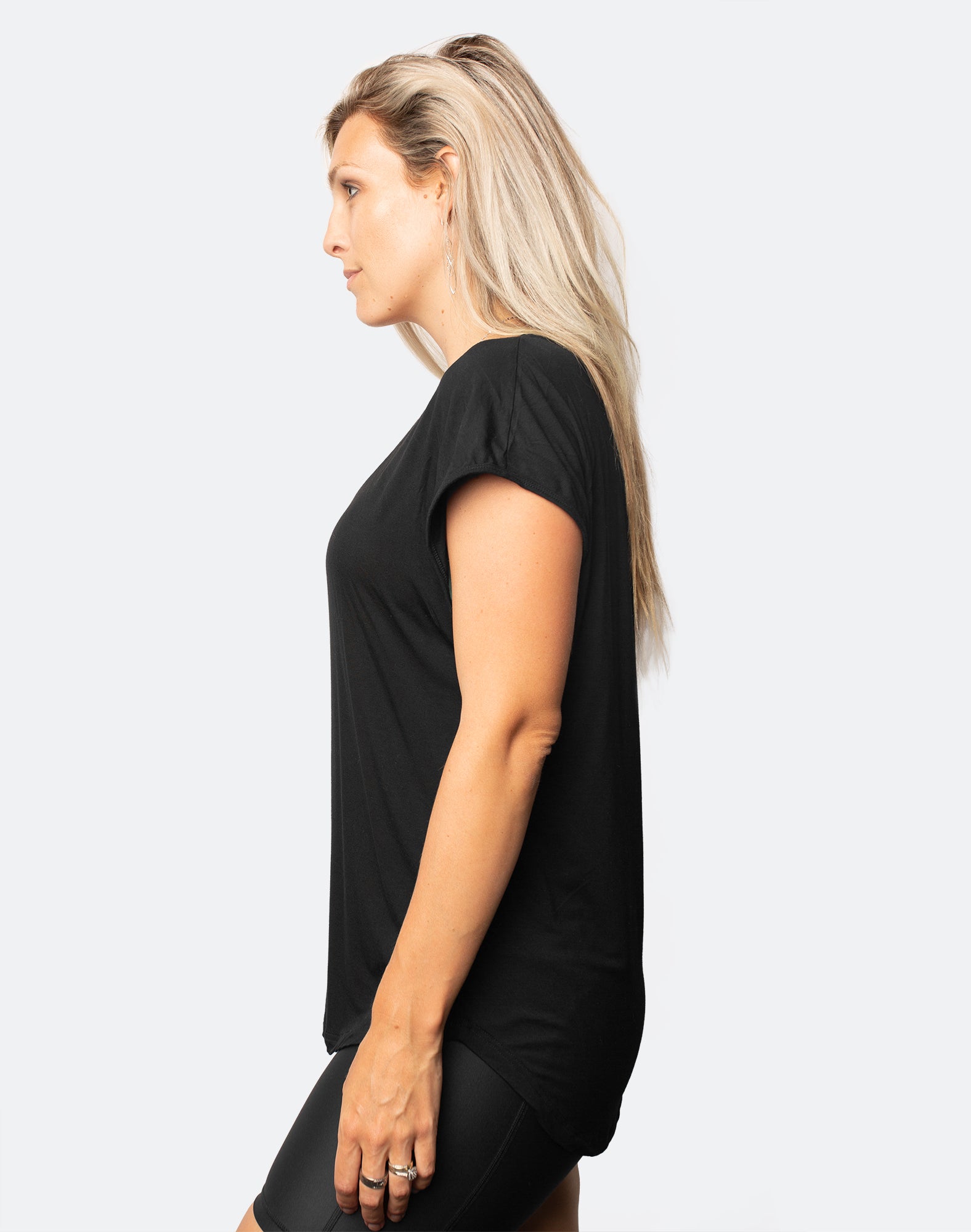 side view of active mum wearing a relaxed fit black tee with wide armholes for breastfeeding