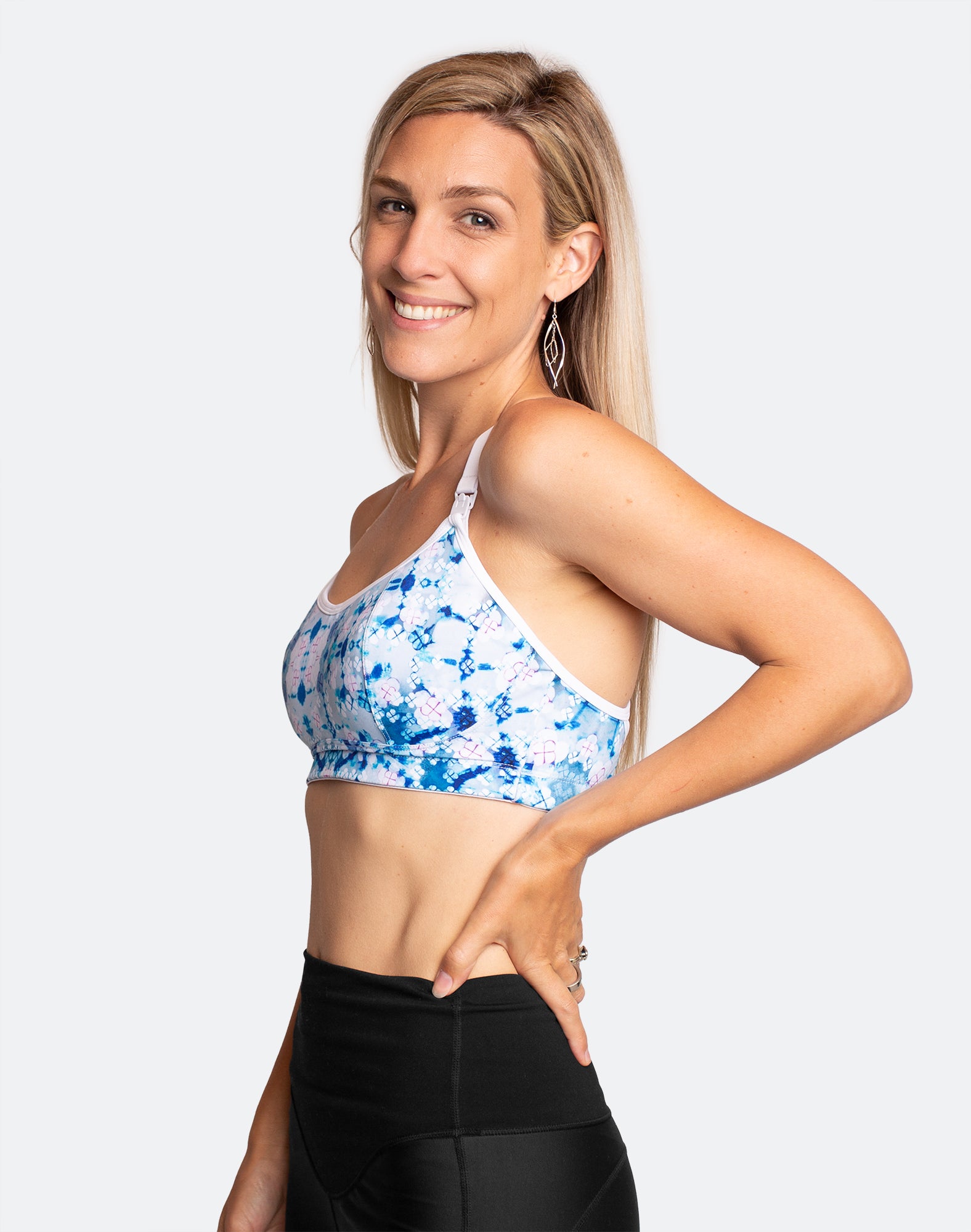 Side angle view of mother wearing blue and white print running nursing bra