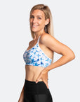 Side angle view of mother wearing blue and white print running nursing bra