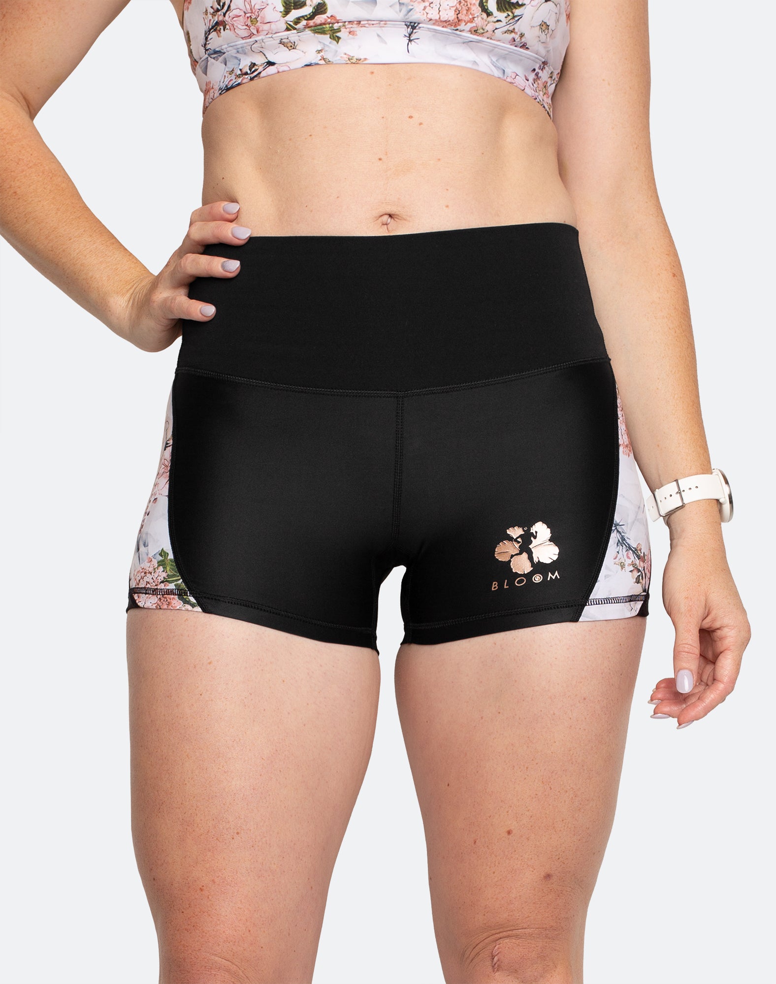 Active mother wearing high waisted black 3 inch maternity shorts with white floral detailing